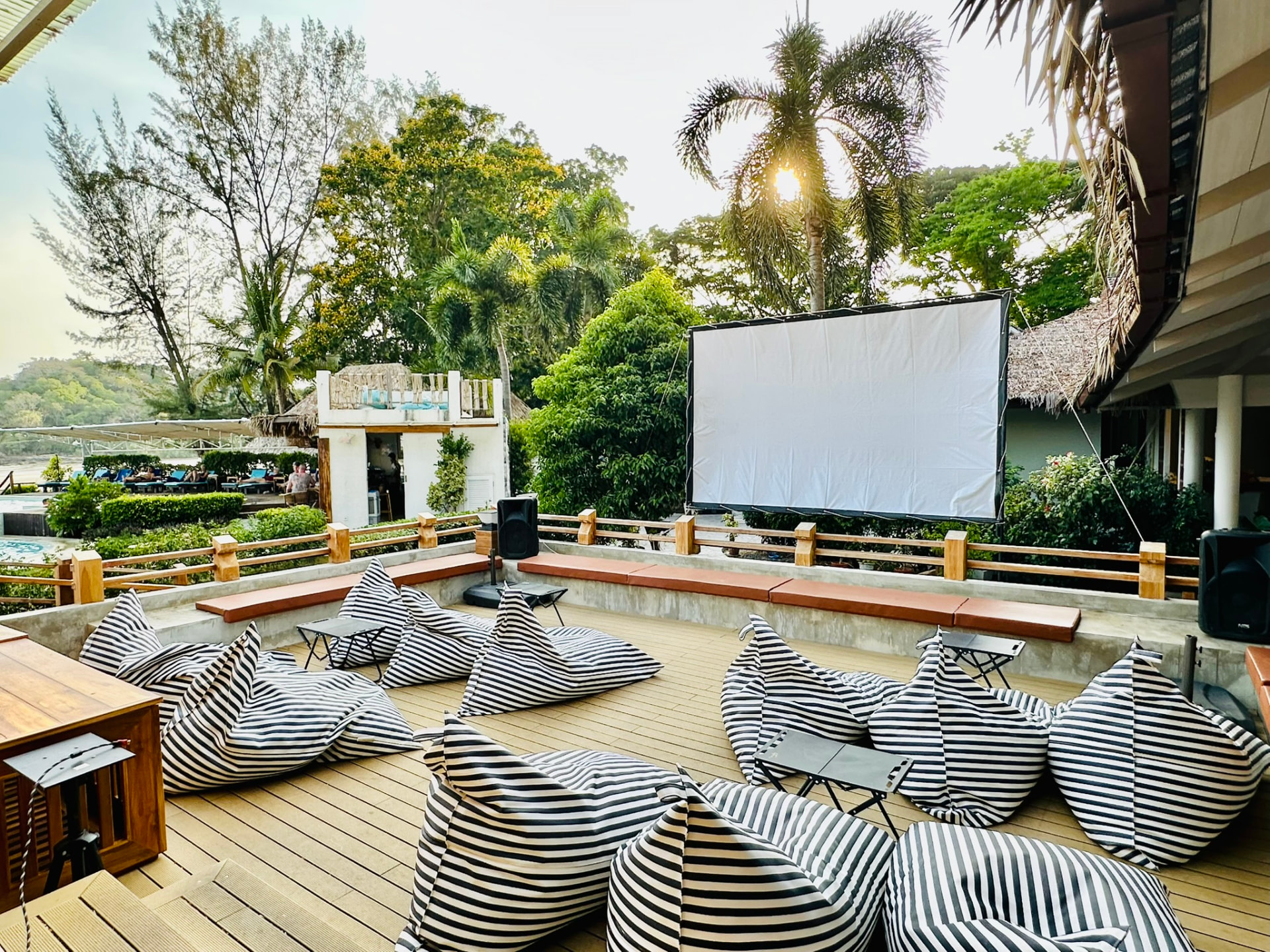 Bean bags facing a screen on the deck before a beach movie night