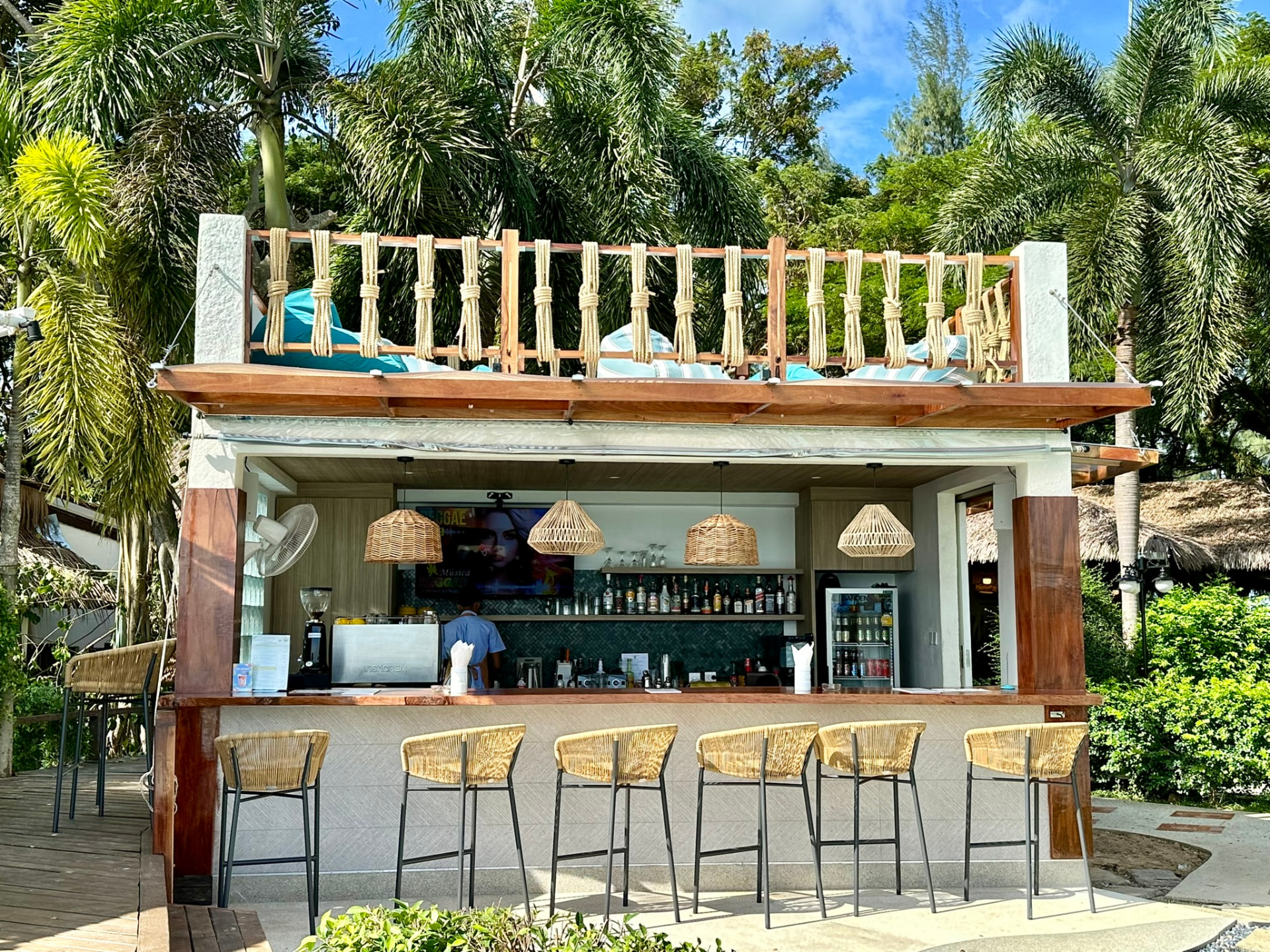 Northstar Bar counter and rattan stools under the palms at TwinBay Resort