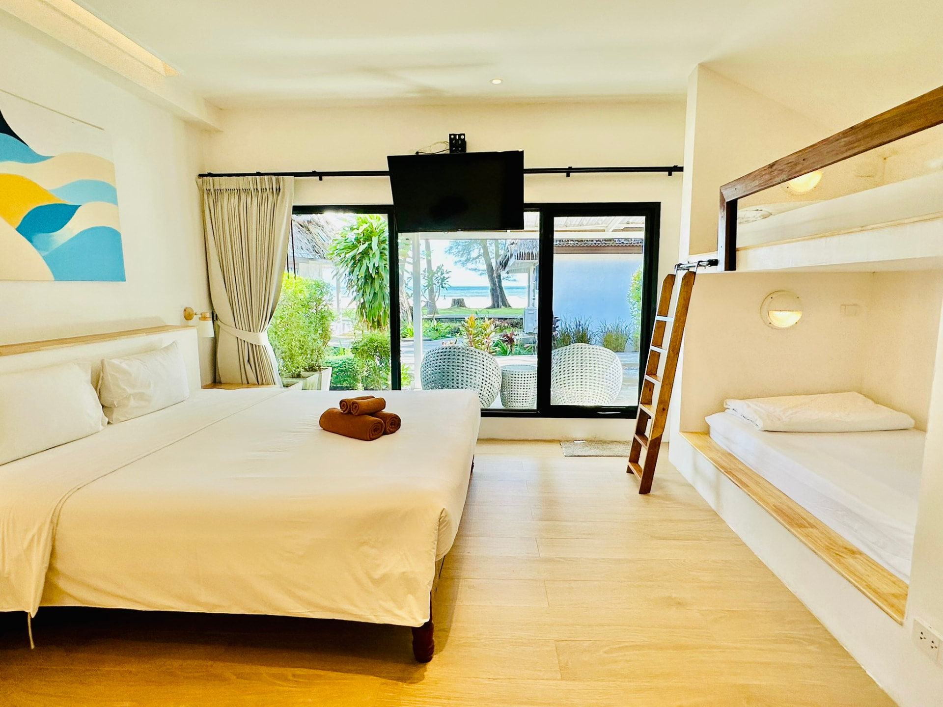 King bed and built-in bunk beds in a Superior Family Bungalow with garden doors open
