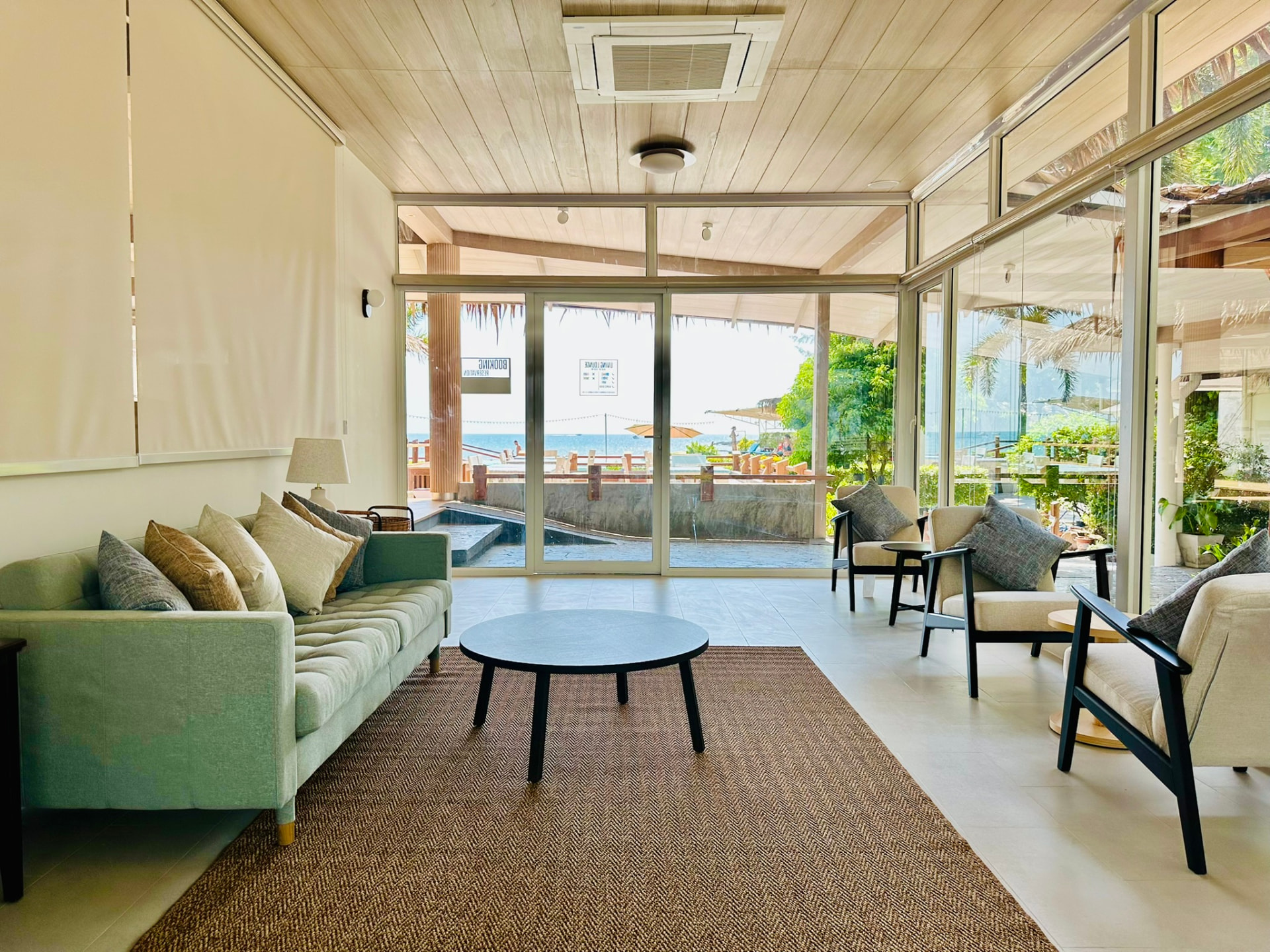 The Living Lounge looking through open doors to the pool and the sea
