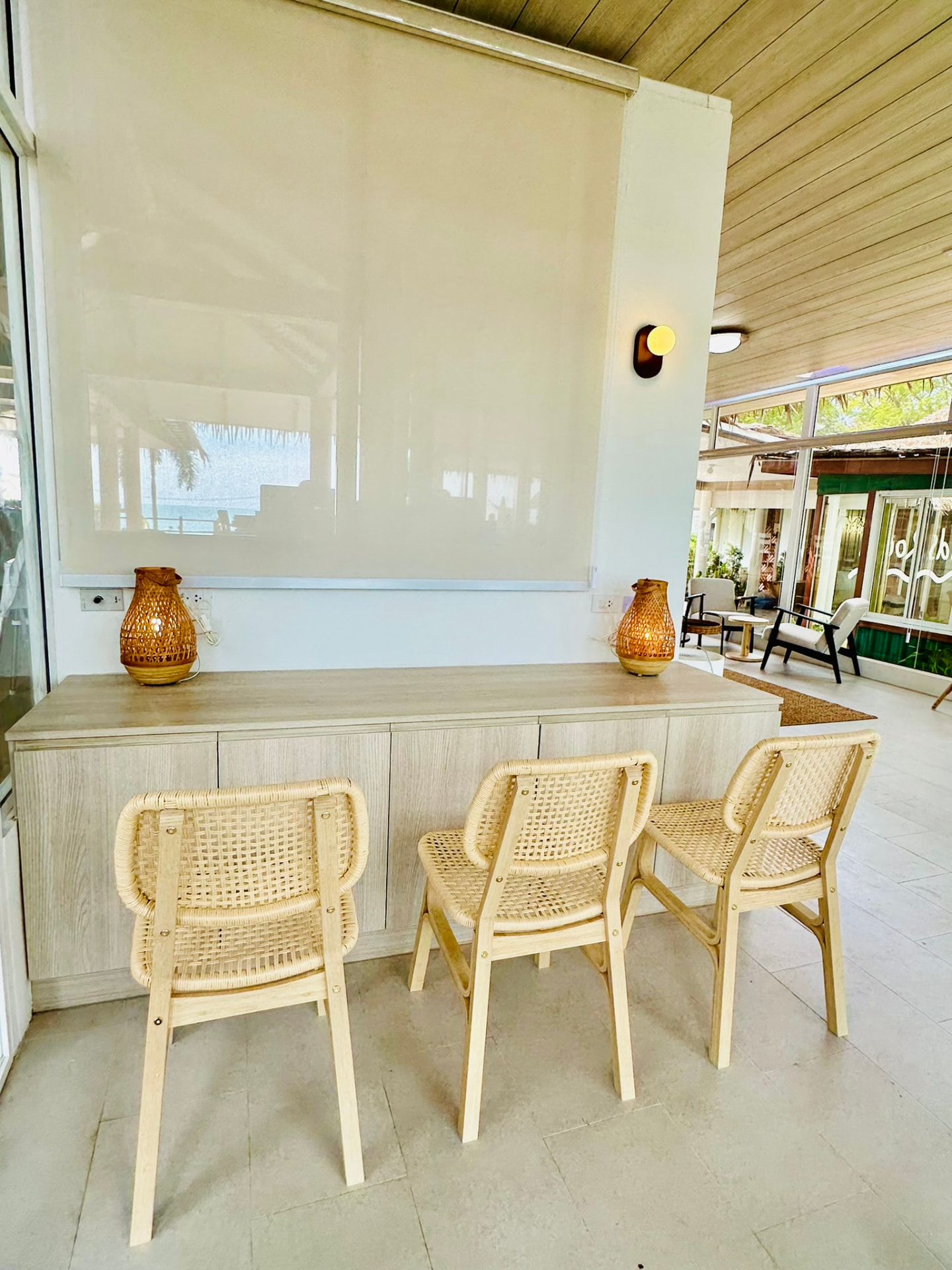 Woven rattan chairs at a light wood counter with basket lamps in the Living Lounge