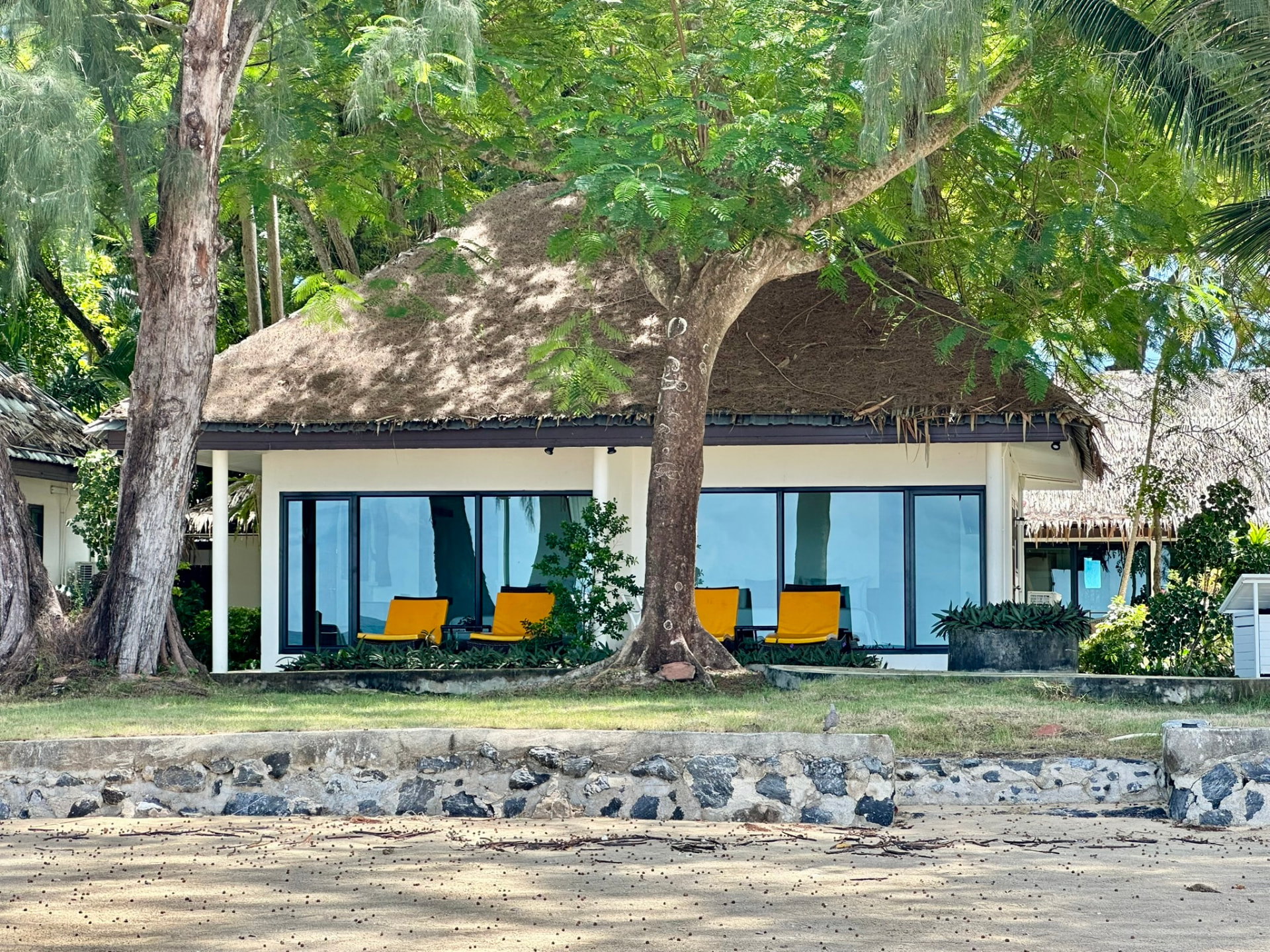 Beachfront bungalow with yellow loungers seen from the sand