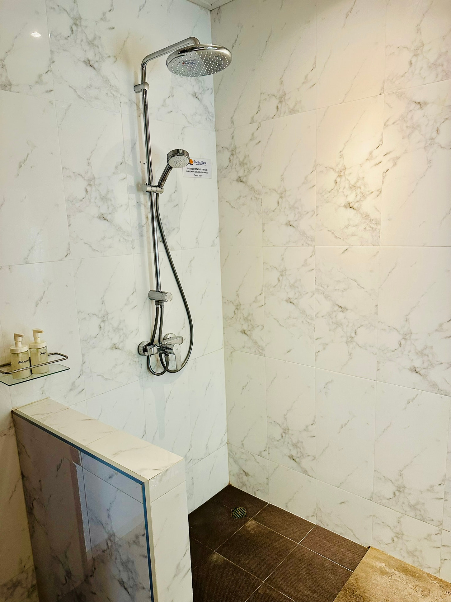 Walk-in rain shower in a marble-tiled bathroom