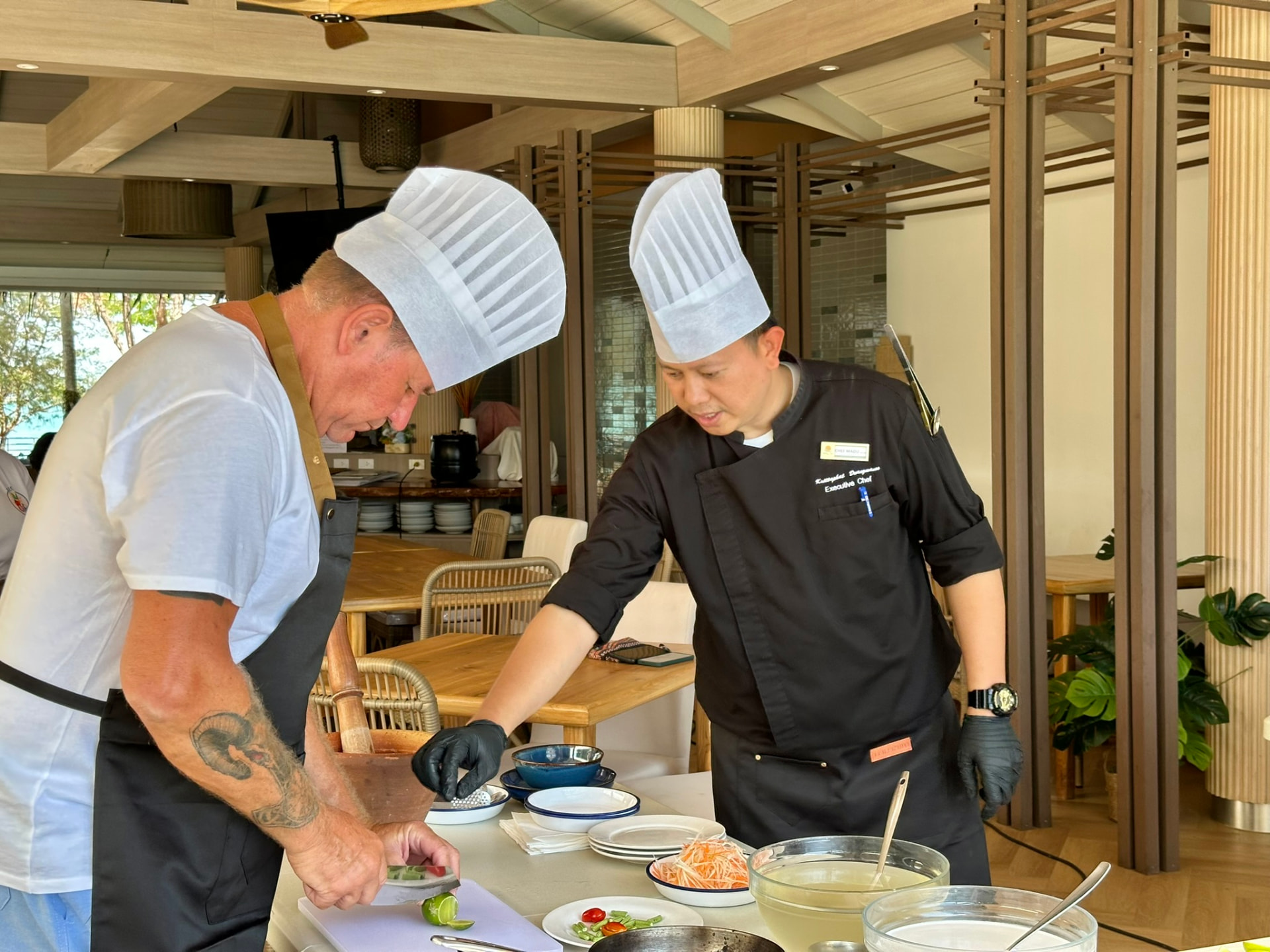 The executive chef showing a guest how to slice for a Thai dish