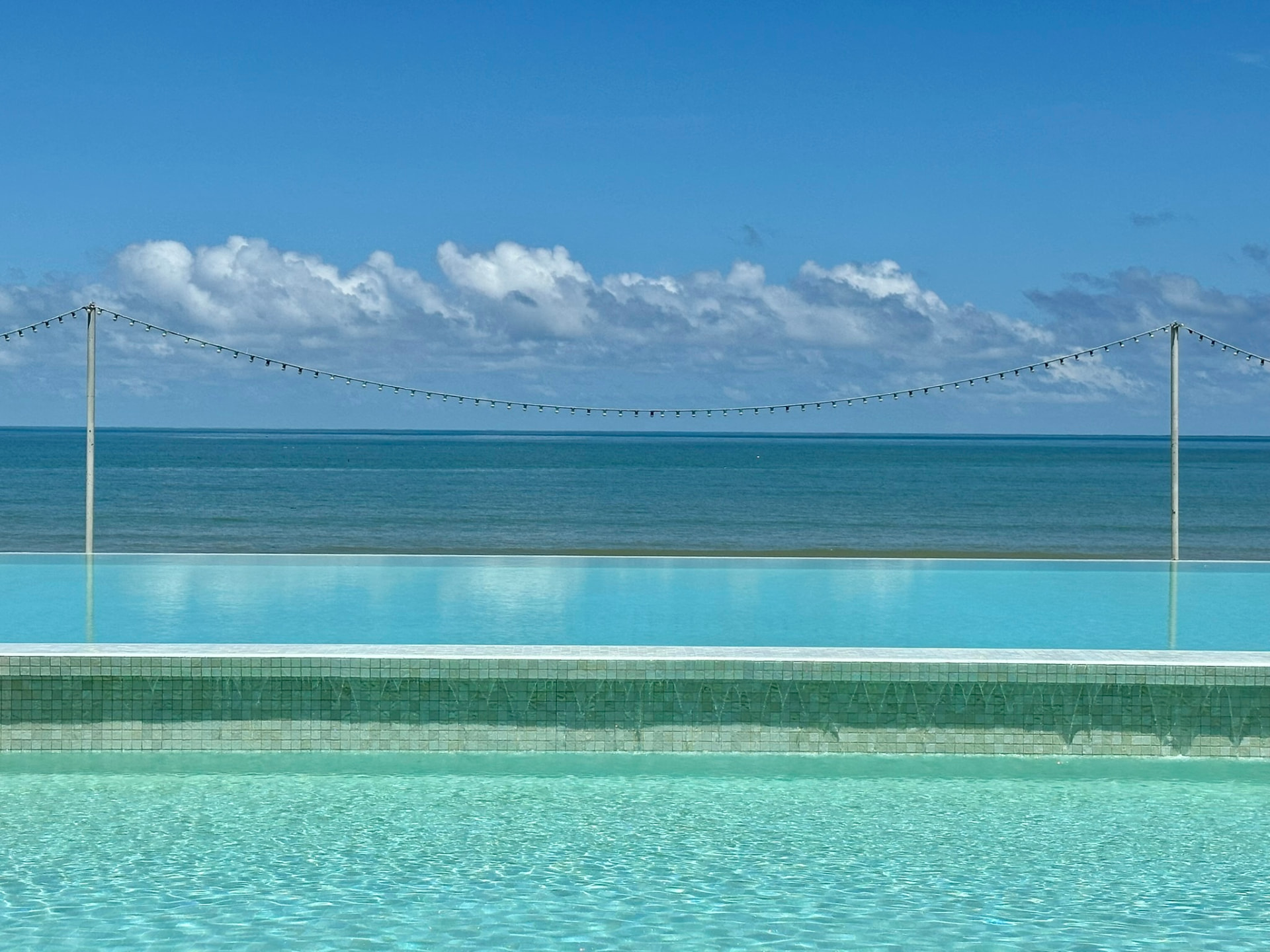 The infinity edge of the pool meeting the sea horizon