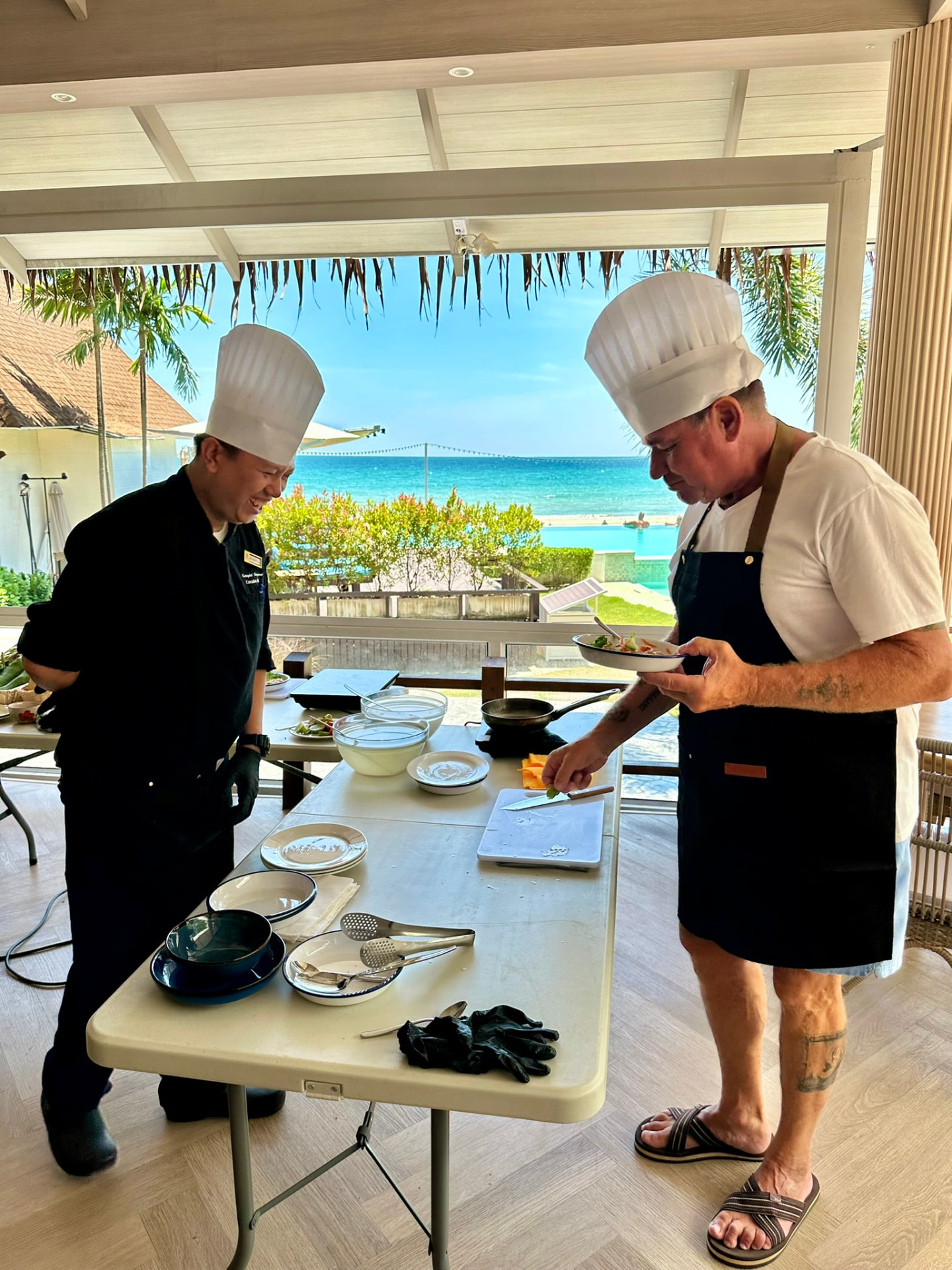 A guest tasting the dish he cooked while the chef looks on