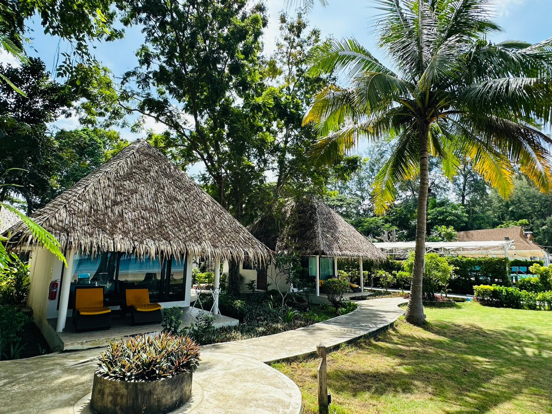 Bungalows on a palm-shaded lawn beside the garden path