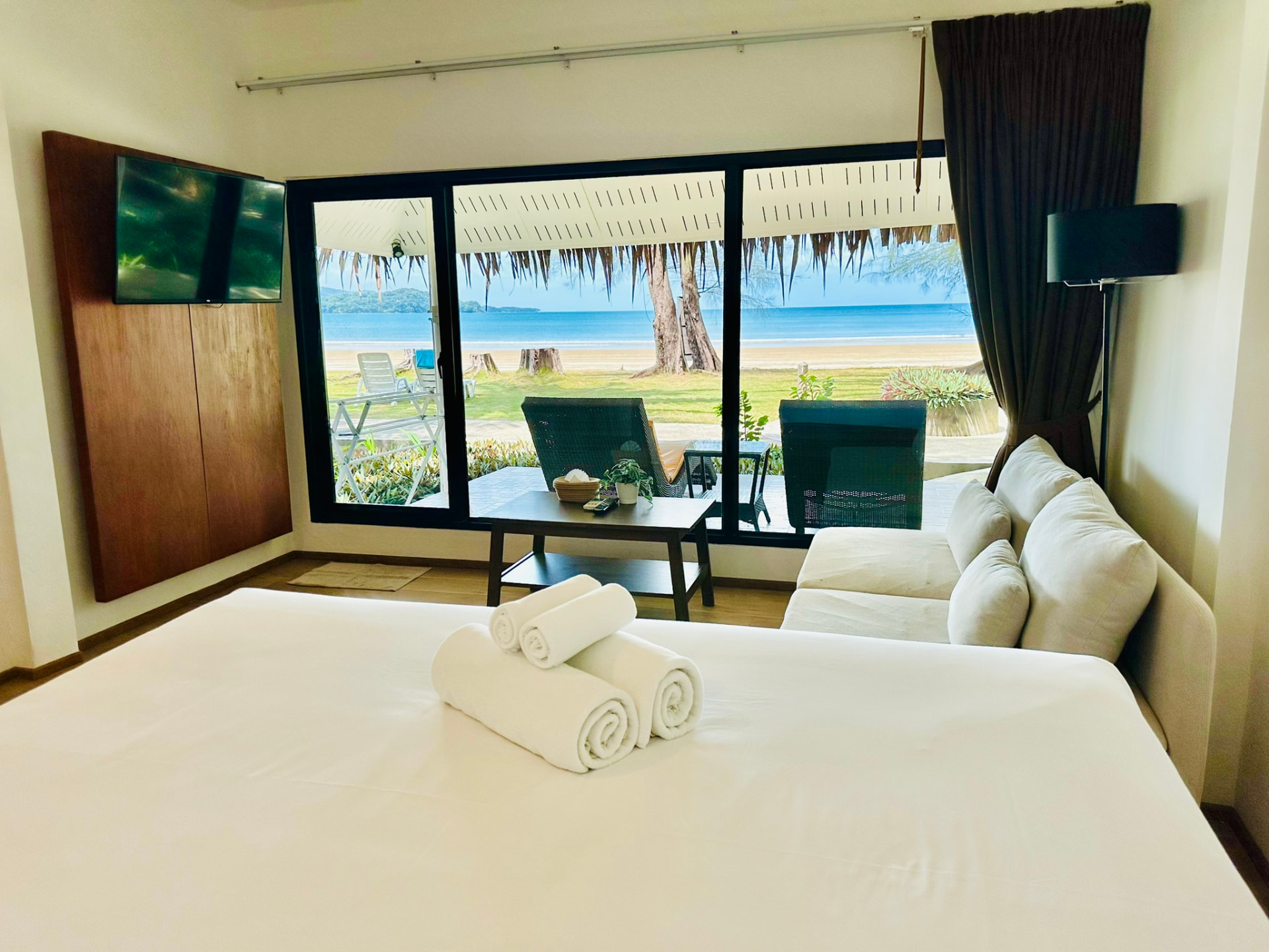 King bed facing sliding doors with the bay and beach beyond