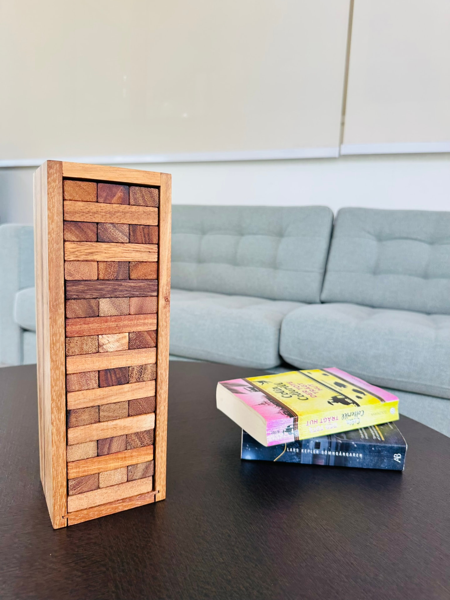 A wooden tumbling-tower game and a stack of paperbacks on the lounge coffee table