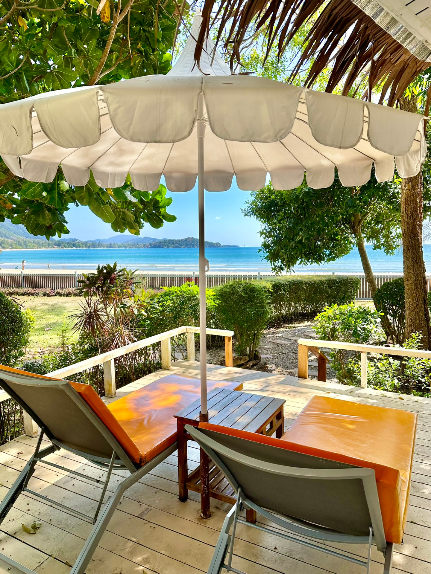 View from the sunbeds under a parasol out to the turquoise bay