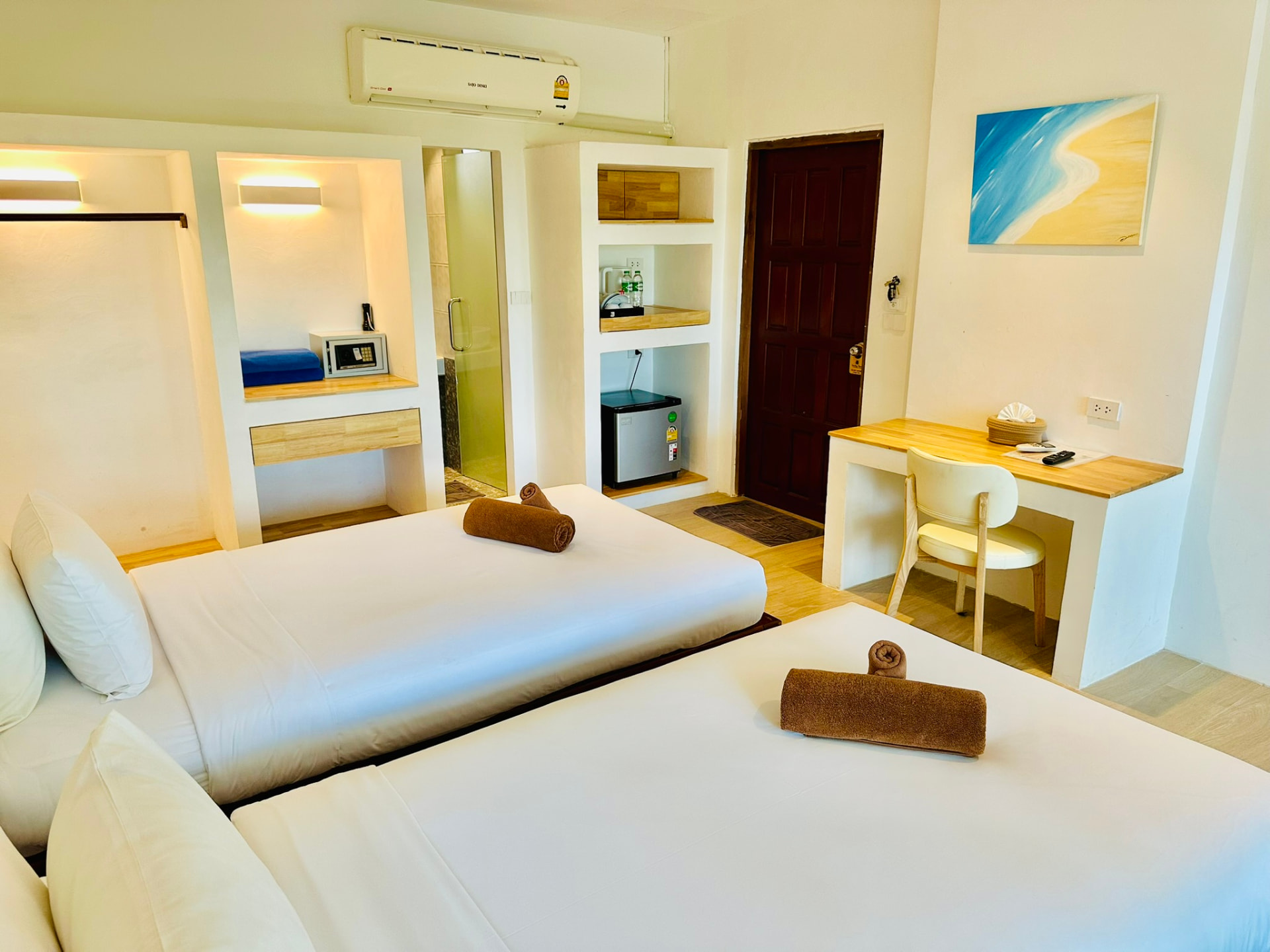 Built-in niches with a safe, kettle, water and mini fridge beside the bathroom