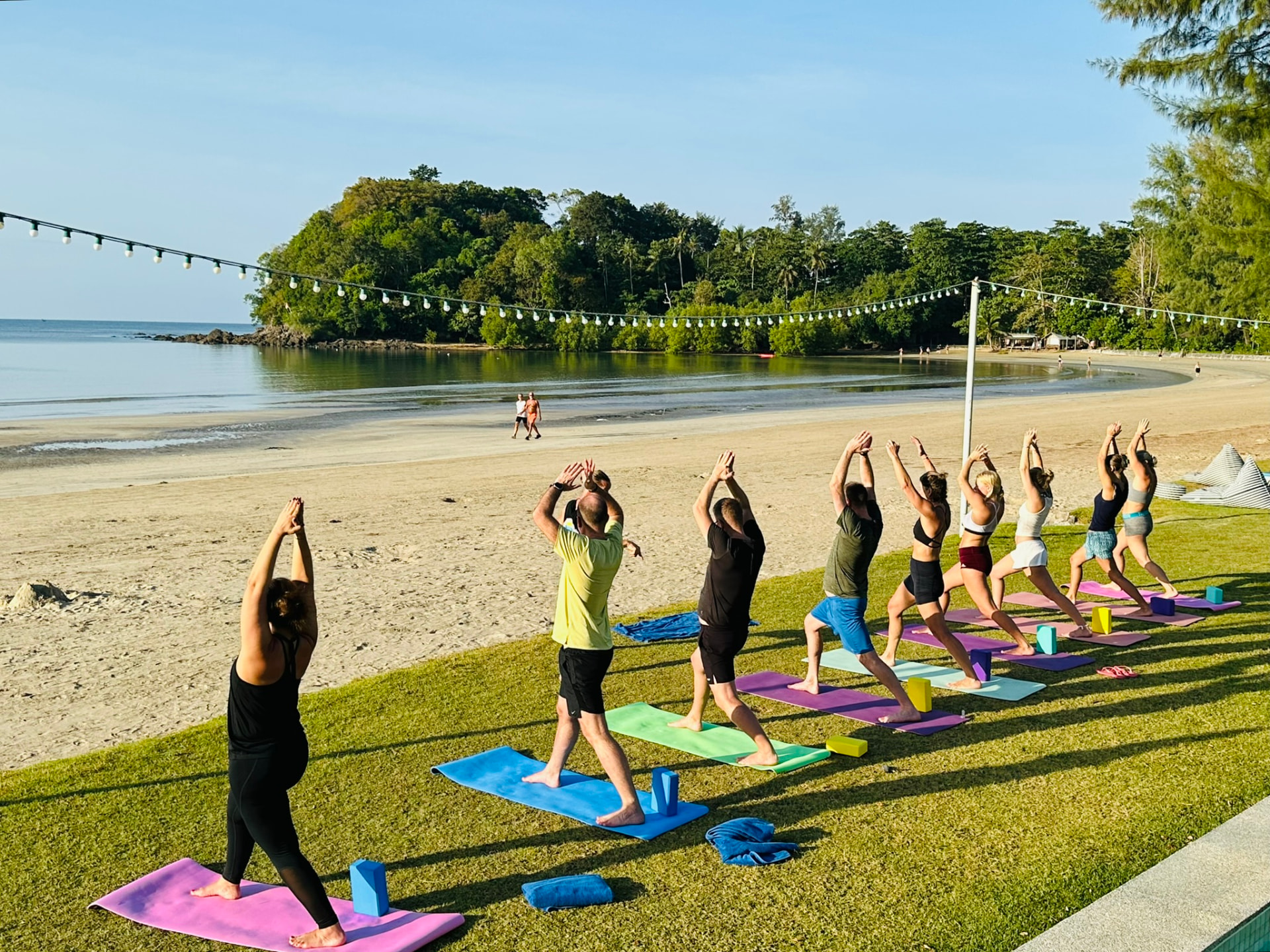 Morning yoga on the lawn with the bay and headland behind
