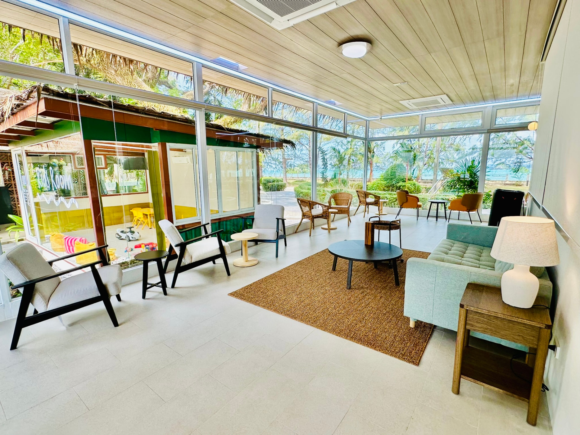 The Living Lounge with the Kids Room visible through the glass and the sea beyond