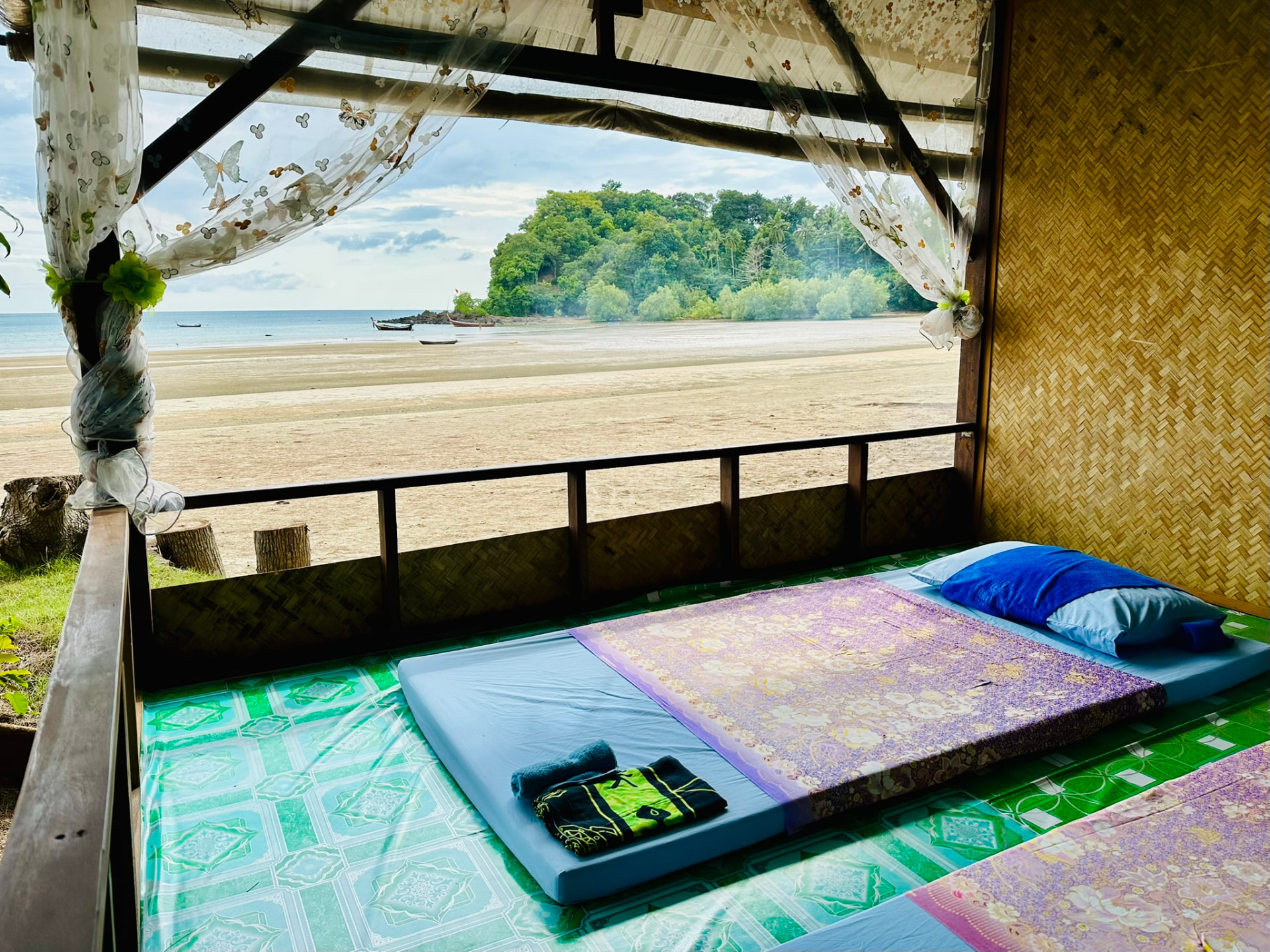 A massage mattress facing the open beach, headland and longtail boats at low tide