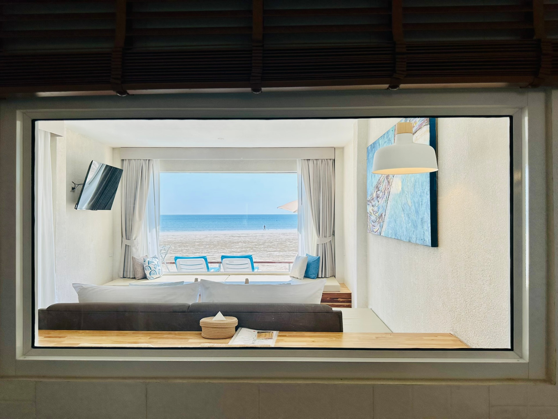 View from the bathroom window through the bedroom to the sea and sunbeds