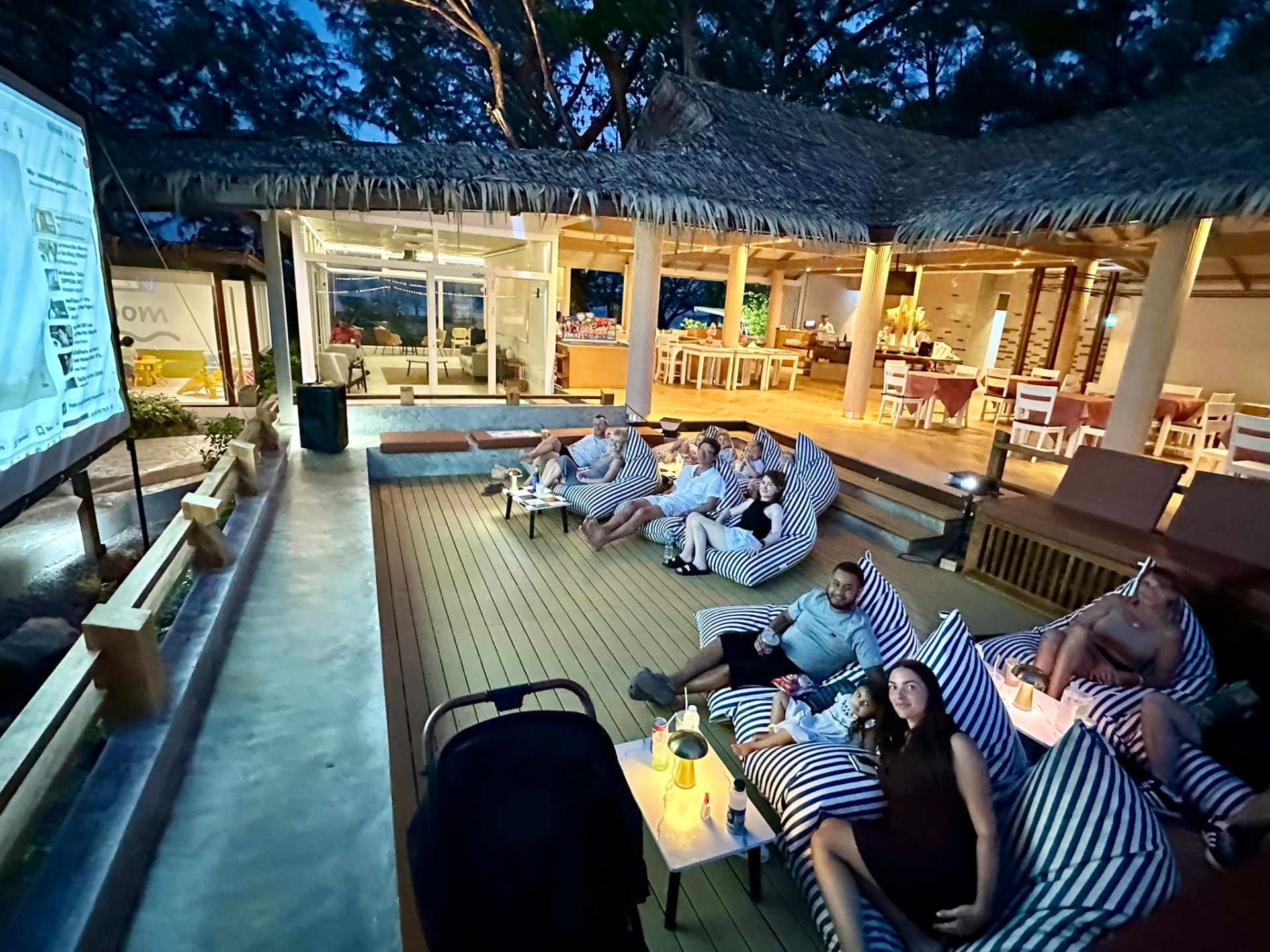 Guests settled together on bean bags under the thatched roof at Breezy Bites