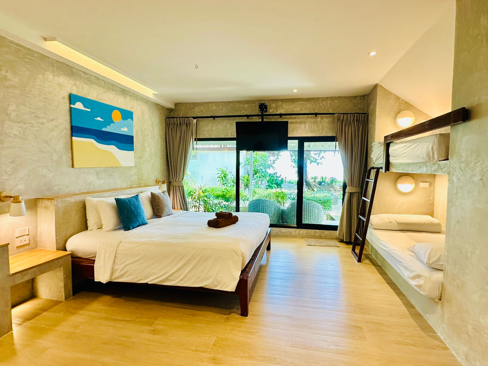 Wide view of a Superior Family Bungalow with king bed, bunk beds and garden doors
