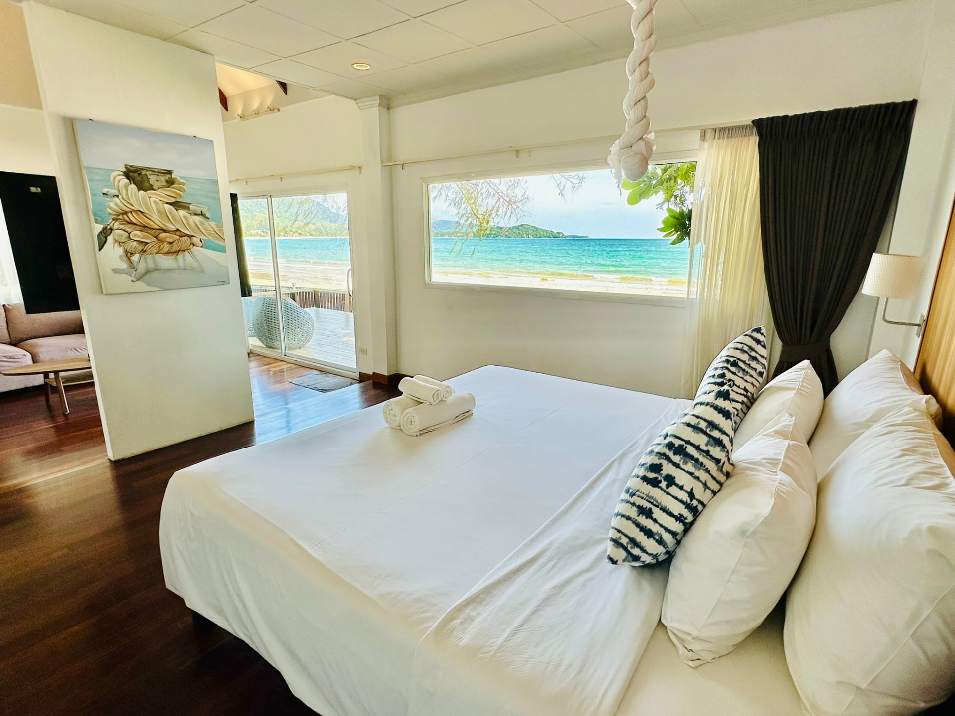 Wide bed with indigo cushions and the sea framed in the window beyond