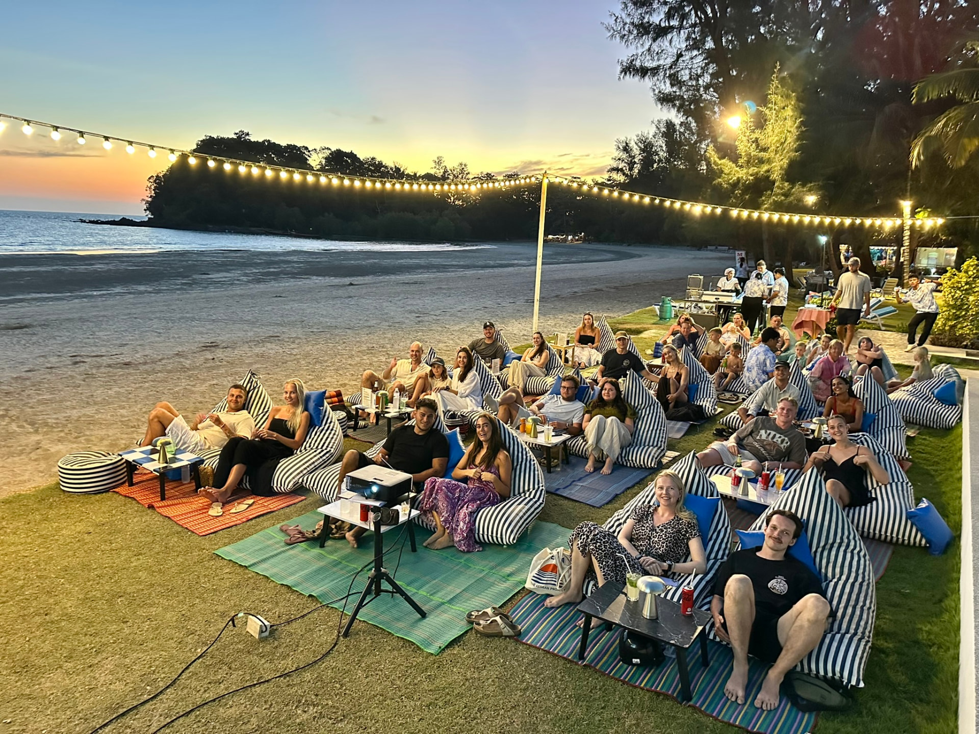 A group of guests together on bean bags on the lawn at sunset