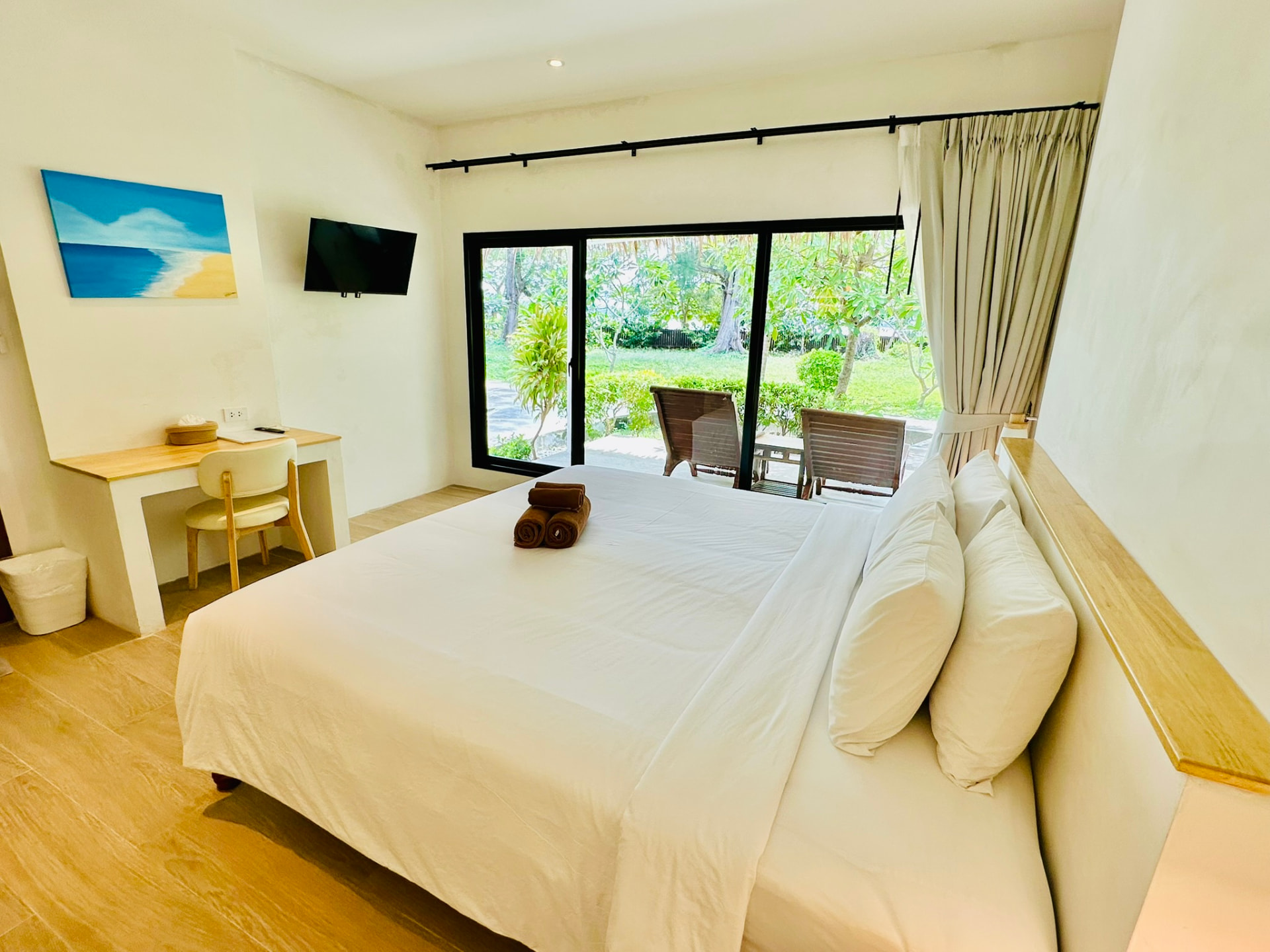 King bed facing sliding doors that open onto the terrace and garden
