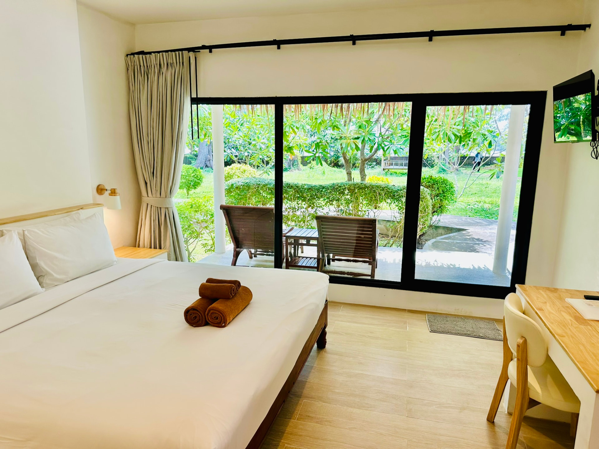 Bedroom looking out through wide windows onto the frangipani garden