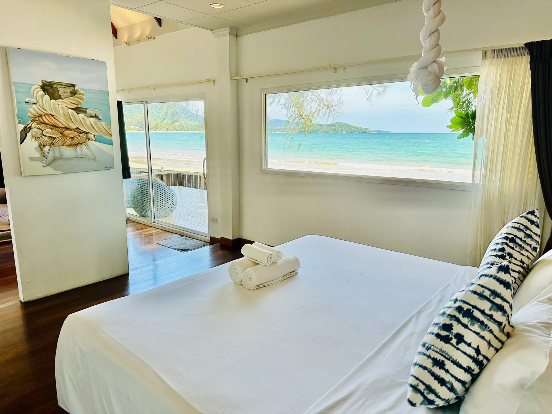 King bed with a long picture window looking straight out to the turquoise bay