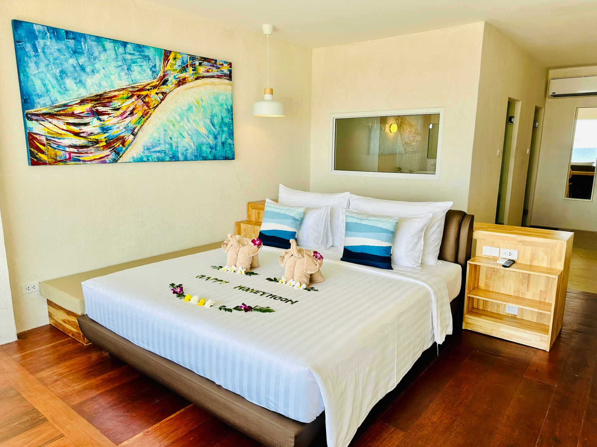 Bedroom with a large painted canvas, pendant light and timber bedside units