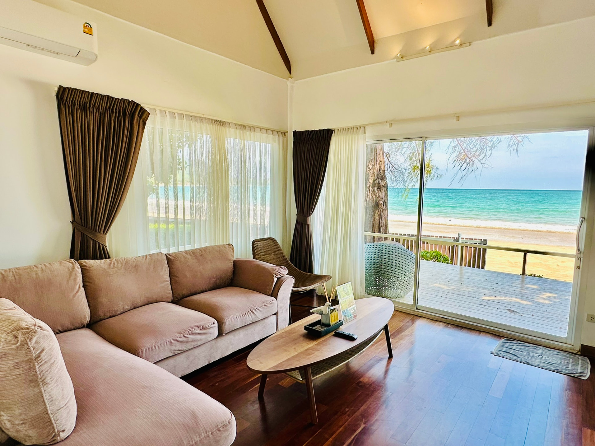 Sitting room with a corner sofa and sliding doors opening onto the beach deck