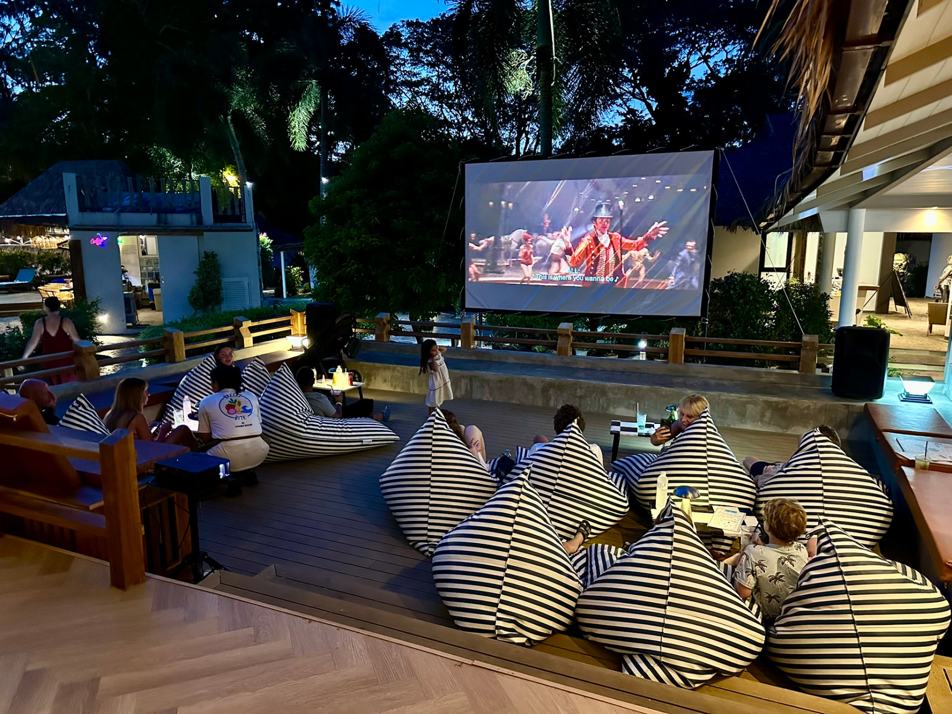Bean bags filled with families watching a musical on the deck at Breezy Bites